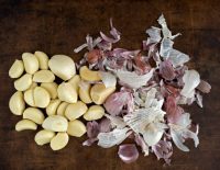 Garlic cloves prepared for cooking on a brown stoneware plate